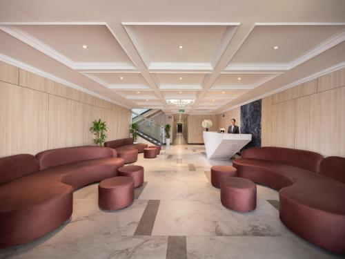 a lobby with brown leather chairs and a counter at M'Gloria Cruise by HAG in Ha Long
