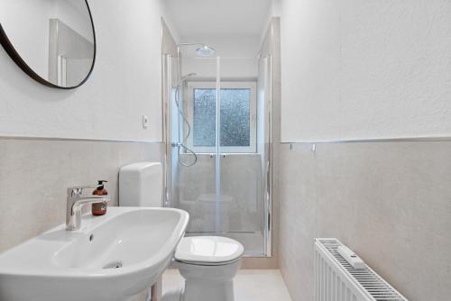 a bathroom with a sink and a toilet and a mirror at Lünen Living Apartment #12 in Lünen