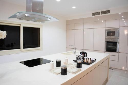 Caves Beach Resort Adults Only في الغردقة: مطبخ أبيض مع حوض وميكروويف