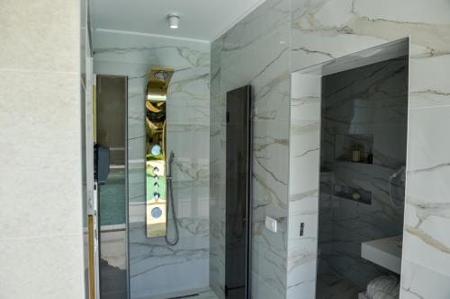 a bathroom with a walk in shower with marble walls at Villa Dolce Vita in Međugorje