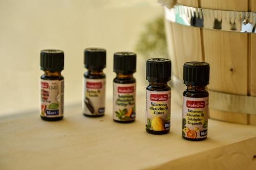 four bottles of essential oils sitting on a wooden shelf at Villa Dolce Vita in Međugorje