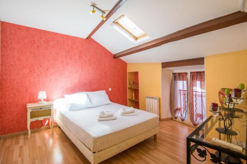 une chambre avec un lit et un mur rouge dans l'établissement Maison le vieux Creissels 4pers balcon parking gratuit, à Creissels