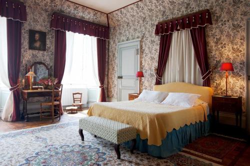 une chambre avec un lit king size et du papier peint à fleurs dans l'établissement Chateau de Sannat, à Saint-Junien-les-Combes