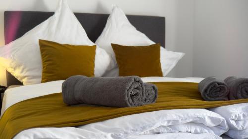 a bed with towels and pillows on it at ARYVE Boutique-Apartments in bester Lage in Bad Hersfeld in Bad Hersfeld