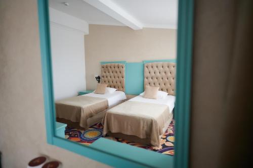 a reflection of a bedroom with two beds in a mirror at Hotel La Castel Iasi in Iaşi