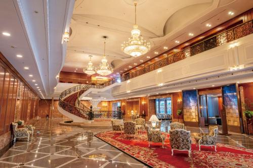 a hotel lobby with a staircase and tables and chairs at Hotel Springs Makuhari Premier in Chiba