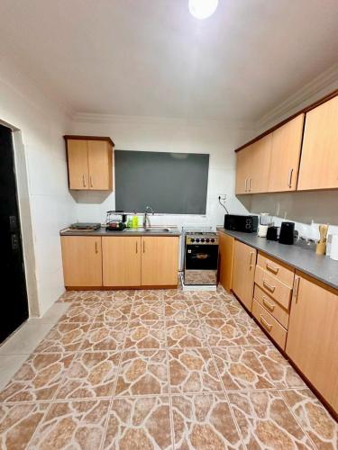 a large kitchen with wooden cabinets and a blackboard at The crown in Oyarifa