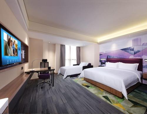 una habitación de hotel con dos camas y un televisor de pantalla plana en Hampton by Hilton Changsha South Railway Station West Square, en Changsha
