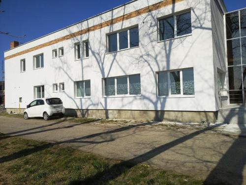a white car parked in front of a building at Penzión Aurora Patince in Patince