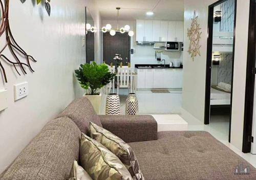 a living room with a couch and a kitchen at Luxury Stay with Balcony, Free Gym & Pool in Bancao-Bancao - B2 6Luster in Puerto Princesa City