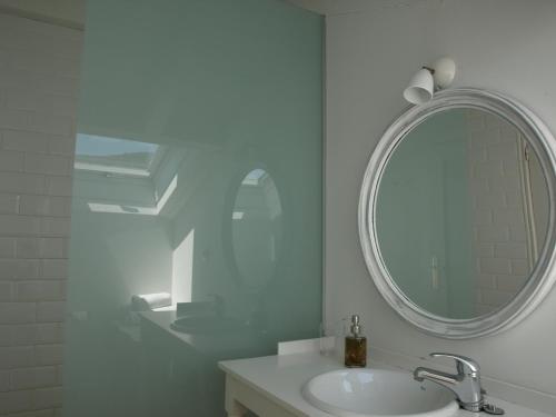a white bathroom with a sink and a mirror at Posada La Panaderia De Castañeda in Villabáñez