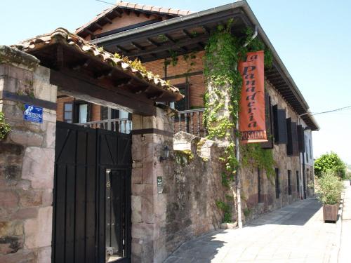a building with a black door and a sign on it at Posada La Panaderia De Castañeda in Villabáñez