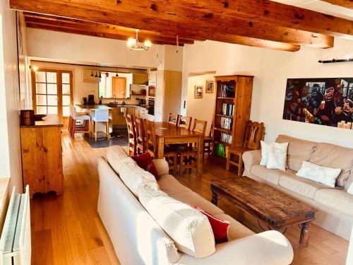 - un salon avec des canapés blancs et une salle à manger dans l'établissement Appart cosy pour 8 personnes, à Samoëns