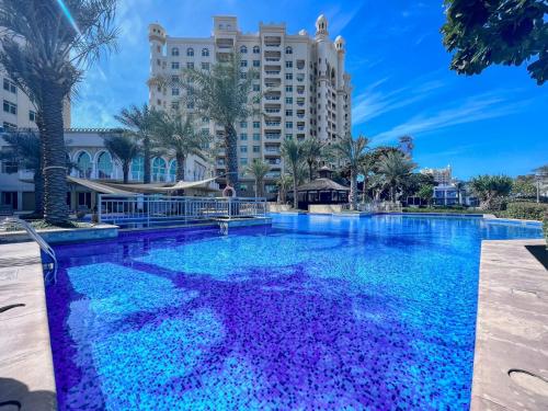 Una gran piscina con un hotel al fondo en GuestReady - Palm Jumeirah delight, en Dubái