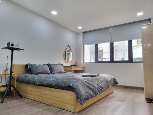 a bedroom with a bed in a room with windows at LoCo Studio with Netflix and Self Checkin in Ho Chi Minh City