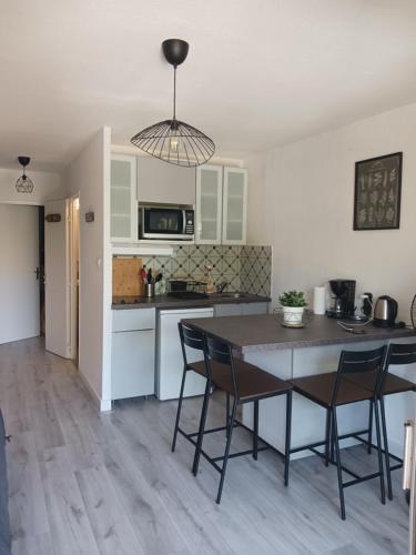 une cuisine avec une table et des chaises dans une pièce dans l'établissement Petit paradis Sanaryen, à Sanary-sur-Mer