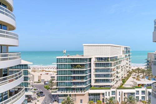 an aerial view of a building with the ocean in the background at Silkhaus Vacation Homes Luxury 2BDR with Maid Room in Ajwan Towers in Abu Dhabi