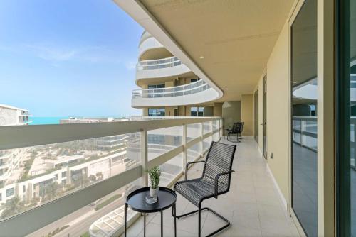 a balcony with chairs and a view of the ocean at Silkhaus Vacation Homes Luxury 2BDR with Maid Room in Ajwan Towers in Abu Dhabi