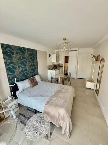 une chambre avec un grand lit et une table dans l'établissement Cannes Carnot 1, à Cannes