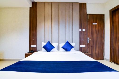 a bedroom with a large bed with blue pillows at Hotel Brill View 500m From ITC Royal Kolkata in Kolkata