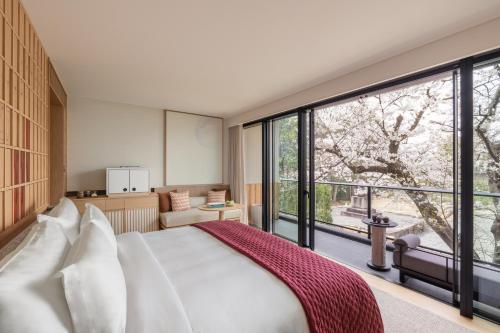 a bedroom with a bed and a large window at Six Senses Kyoto in Kyoto