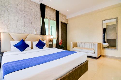 a bedroom with a large bed with blue pillows at Hotel Brill View 500m From ITC Royal Kolkata in Kolkata