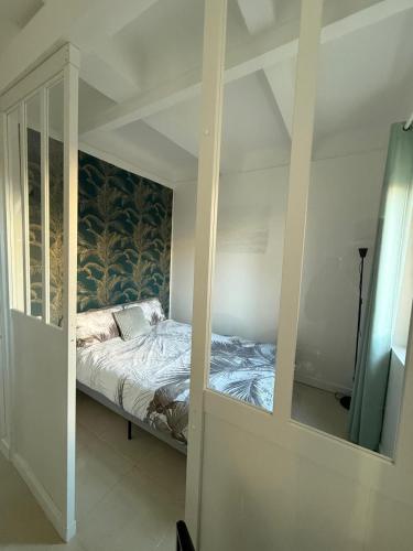 Cette chambre comprend un lit et un miroir. dans l'établissement Le Suquet, à Cannes