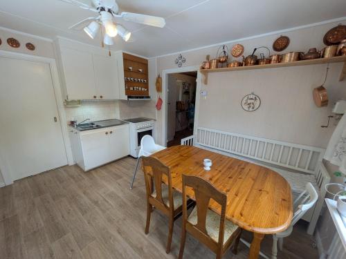 a kitchen and dining room with a wooden table and chairs at Charming Family-Friendly Villa in Lesjöfors
