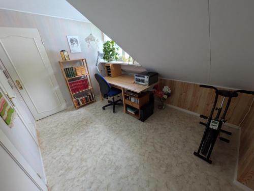 an attic office with a desk and a chair at Charming Family-Friendly Villa in Lesjöfors