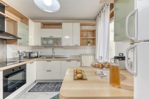 a kitchen with white cabinets and a table with a bowl of bread at Villa Urso in Ugento