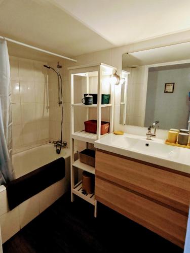 une salle de bain avec un lavabo, une baignoire et un miroir dans l'établissement Appartement 78m - Millau centre - L'échappée belle, à Millau