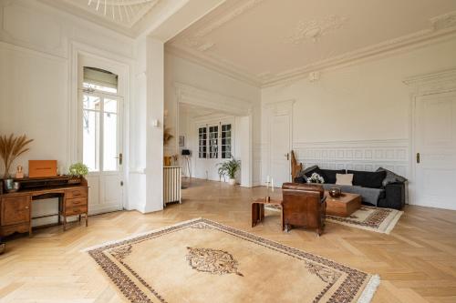 a large living room with a couch and a piano at Hôtel particulier - Le 119 in Valenciennes