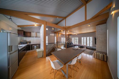 a kitchen and dining room with a table and chairs at Powdersuites by The Hakuba Collection in Hakuba
