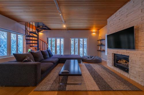 a living room with a couch and a fireplace at Powdersuites by The Hakuba Collection in Hakuba