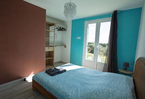 une chambre avec un lit aux murs bleus et une fenêtre dans l'établissement Villa Amandine, à La Verdière