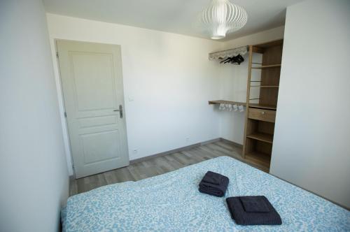 - une chambre avec un lit et 2 chaussons noirs dans l'établissement Villa Amandine, à La Verdière