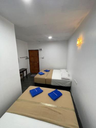 a room with two beds and a table in it at Perhentian Najmi Hotel in Perhentian Island