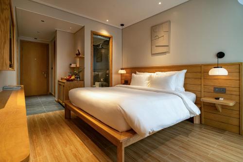 a bedroom with a large white bed in a room at Nam Dat Hotel by D'Lecia Ha Long in Ha Long