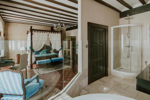 a bathroom with a glass shower and a tub at Hospedería Palacio de Casafuerte in Zarratón