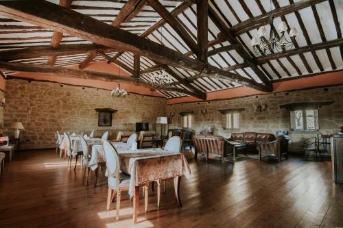 Un comedor con mesas y sillas y una pared de ladrillos. en Hospedería Palacio de Casafuerte, en Zarratón