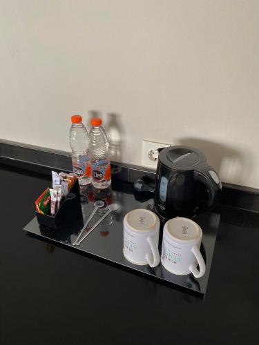 a tray with water bottles and coffee cups on a table at Nemuru Grand Bhuvana Ciawi in Bogor