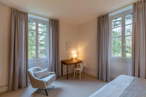 a bedroom with a bed and a chair and a desk at La Reverdie in Cahuzac-sur-Vère