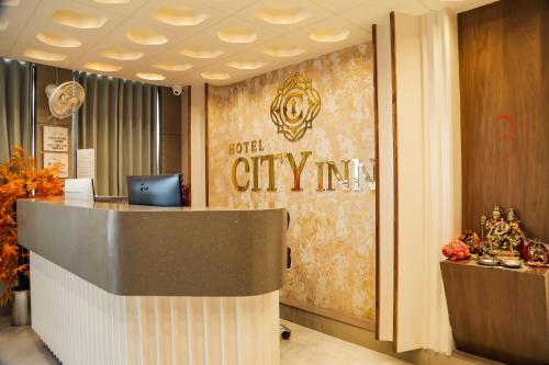 a hotel lobby with a hotel citymite sign on the wall at Hotel city inn in Ahmedabad