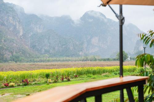 a view of a field with mountains in the background at บ้านในสวน รีสอร์ท หุบป่าตาด in Ban Dong
