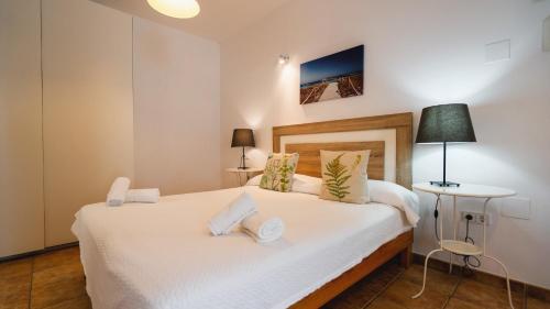 a bedroom with a bed with white sheets and pillows at Apartamentos Es Pou - Emar Hotels in Sant Ferran de Ses Roques