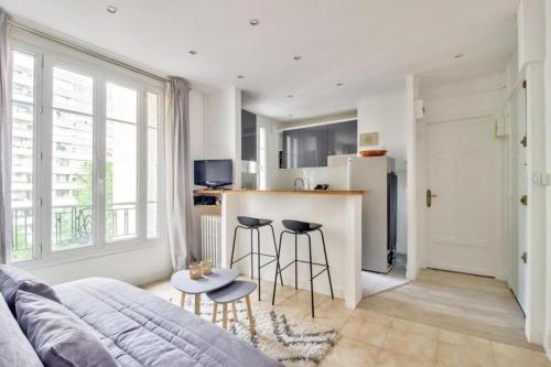 un salon avec un canapé et une cuisine dans l'établissement Nice Flat Jules Joffrin station and Clignancourt, à Paris