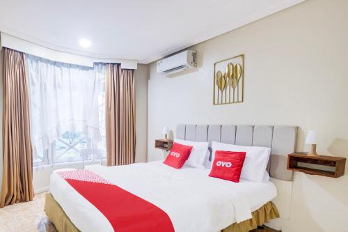 a bedroom with a large bed with red pillows at Hotel O Bogor Near Museum Peta in Bogor
