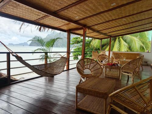 a porch with a hammock and a view of the ocean at La Sirenne Inn in El Nido