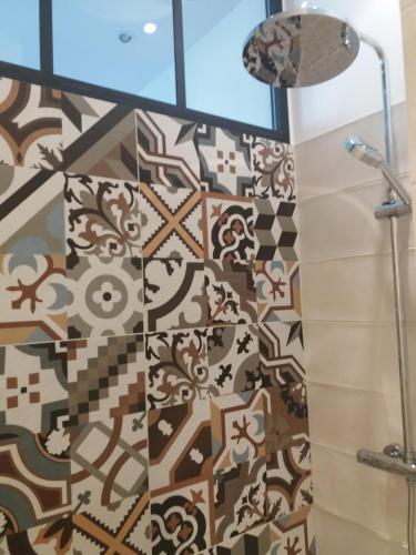 La salle de bains est pourvue d'une douche et d'un mur en carrelage. dans l'établissement Gorgeous! heart of Aix en Provence appartement climatisé, à Aix-en-Provence