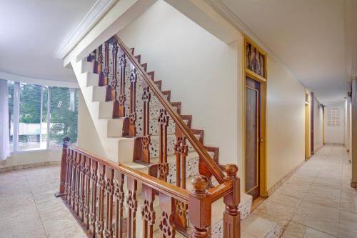 a staircase in a home with wooden railings at Hotel O Bogor Near Museum Peta in Bogor